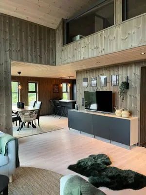 a living room with a tv and a couch and a table at Polaren by Norgesbooking - cabin with amazing view in Notodden