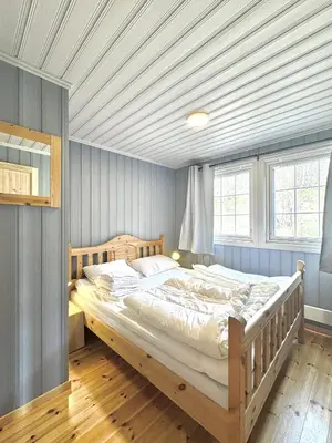 a bedroom with a large bed in a room with blue walls at Cottage Yard - cozy Cabin in Geilo