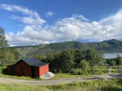 a smallshed on the side of a road next to a lake at Cottage Yard - cozy Cabin in Geilo