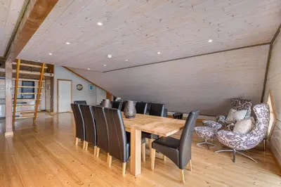 a dining room with a wooden table and chairs at Atlantic Road Seaside Housing in Averoy