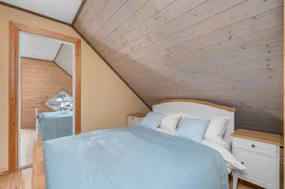 a bedroom with a bed and a wooden ceiling at Atlantic Road Seaside Housing in Averoy