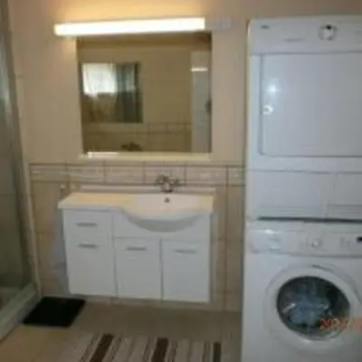a bathroom with a washing machine and a sink at Feriehus Voldstad in Syvde