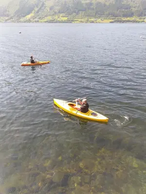 two people in kayaks on a body of water at Feriehus Voldstad in Syvde