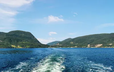 a boat in a large body of water with mountains at 2 Bedroom Stunning Home In Foldfjorden in Skogli