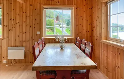 a dining room with a wooden table and chairs at 2 Bedroom Stunning Home In Foldfjorden in Skogli