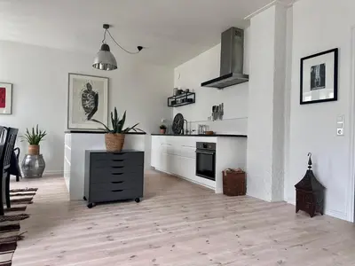 a kitchen with white walls and a black cabinet in it at Stunning penthouse in the city! in Ålesund