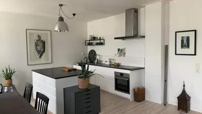 a kitchen with white walls and a black counter top at Stunning penthouse in the city! in Ålesund