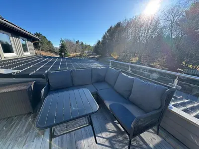 a couch and a table on a deck at Eksluzywny apartament w zaciszu in Kristiansund
