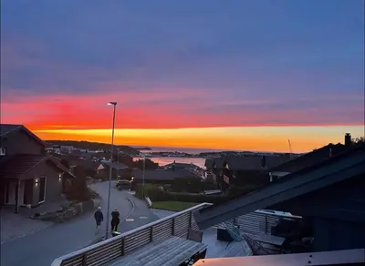 two people walking down a street at sunset at Eksluzywny apartament w zaciszu in Kristiansund