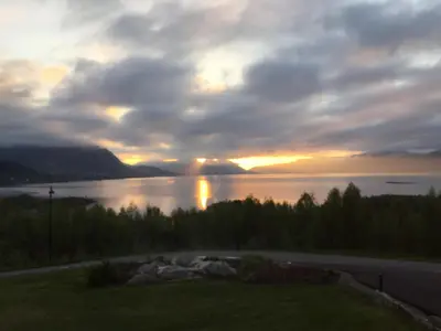 a sunset over a body of water with the sun setting at Sivert´s kontorhotell in Tomrefjord