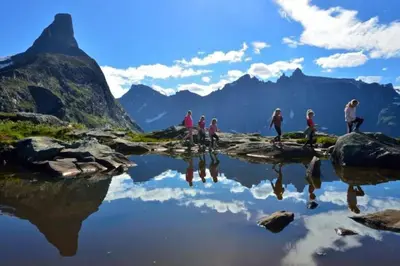 a group of people standing around a lake in the mountains at Villa i Isfjorden! in Isfjorden