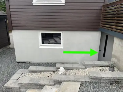 a building with a window with a green arrow at A Cozy Place To Stay Over in Tysvær