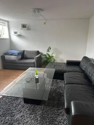 a living room with a couch and a glass table at A Cozy Place To Stay Over in Tysvær
