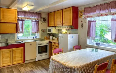 a kitchen with a white refrigerator and a table at Stunning Home In Verma With Kitchen in Bjorli