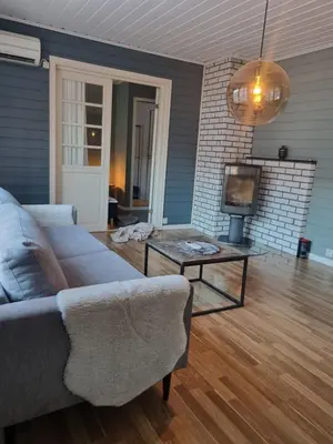 a living room with a couch and a table and a tv at Stor leilighet med 4 senger sentralt i Førde in Førde