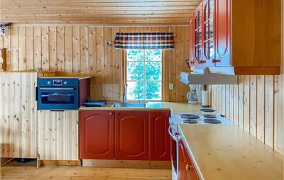 a kitchen with red cabinets and a blue stove at 3 Bedroom Nice Home In Bjorli in Bjorli