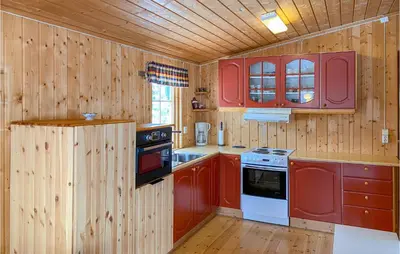 a kitchen with wooden walls and red cabinets at 3 Bedroom Nice Home In Bjorli in Bjorli