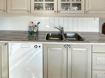 a kitchen with a stainless steel sink and white cabinets at 10 person holiday home in Snillfjord-By Traum in Snillfjord