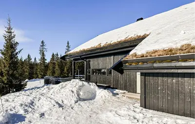 a building with a pile of snow in front of it at Cozy Home In Sjusjøen With Kitchen in Sjusjøen