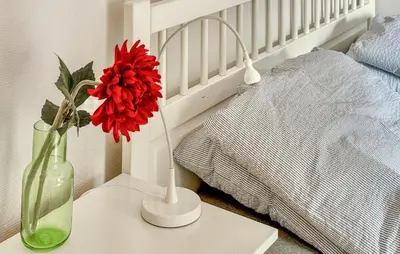a red flower in a vase on a table next to a bed at Cozy Apartment In Uggdal With Wifi in Uggdal
