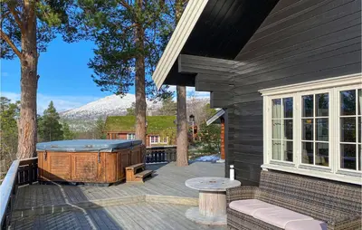 a hot tub on a deck next to a house at Gorgeous Home In Bjorli With Wifi in Bjorli