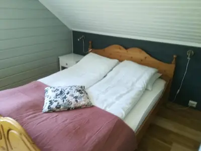 a bed with white sheets and a pillow on it at Hesthaug Gard in Eidsdal