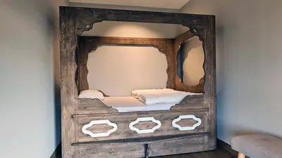 a wooden frame with a bed in a room at Huso Mountain Lodge - Hemsedal in Eikregardane