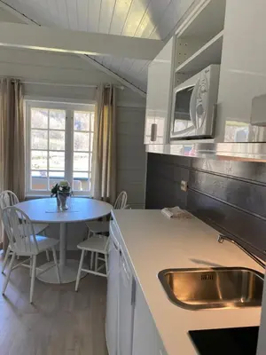 a kitchen with a sink and a table with a table at Nygård Camping in Hjelle
