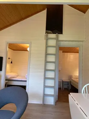 a tiny house with two beds and a ladder at Nygård Camping in Hjelle