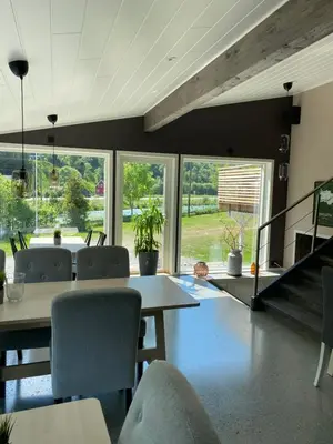 a dining room with a table and chairs and windows at Nygård Camping in Hjelle