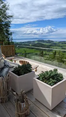 a patio with two planters on a wooden deck at Forbord Dome in Tilleraune