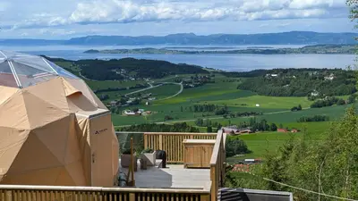 a tent on a deck with a view of a lake at Forbord Dome in Tilleraune