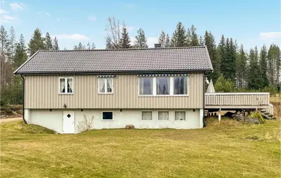 a house with a deck on top of a yard at Cozy Home In Østby With Wifi in Trysil