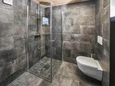 a bathroom with a toilet and a glass shower at Ski-in-out hytte på Kvitfjell in Strande