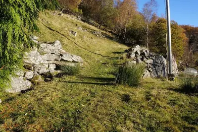 a grassy hill with a pile of rocks on it at Bregnehytte in Leikanger