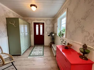 a hallway with a red table and a red door at Beautiful Private Villa with Lake View and Boat in Hålland