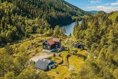 an aerial view of a house on a hill next to a lake at Beautiful Private Villa with Lake View and Boat in Hålland