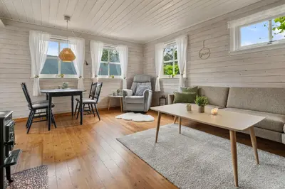 a living room with a couch and a table at Fjord Lodge direkt am Ufer des Dalsfjord in Lauvstad