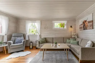 a living room with a couch and a table at Fjord Lodge direkt am Ufer des Dalsfjord in Lauvstad