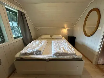 a bed in a small room with a mirror at Cabin with a great view at Gaustablikk in Gaustablikk