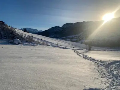 a snow covered slope with the sun in the background at Moderne hytte i Svandalen, Sauda - nær skisenter og natur in Sauda