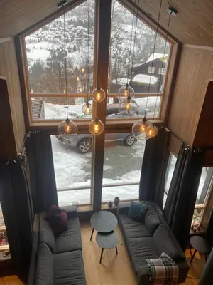 a living room with a couch and a large window at Moderne hytte i Svandalen, Sauda - nær skisenter og natur in Sauda