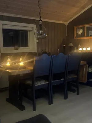 a dining room table with chairs and a chandelier at Hytte med Anneks og fantastisk utsikt på Ljøsheim in Mesnali