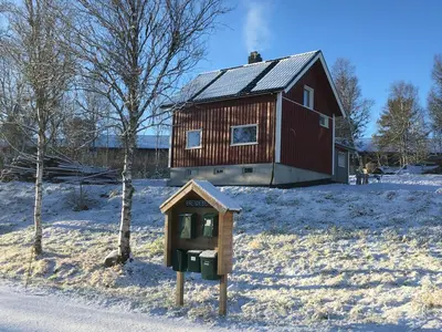 a wooden house with a parking meter in the snow at Apartment Grønlid in Rauland