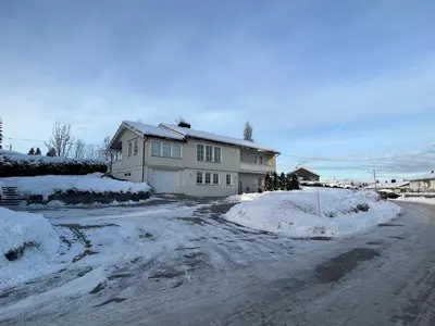 a house is covered in snow on a street at Koselig rom i rolige omgivelser in Rena