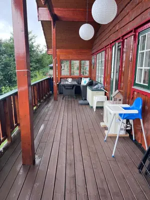 a porch of a wooden cabin with a table and chairs at Domek Iwony in Molde