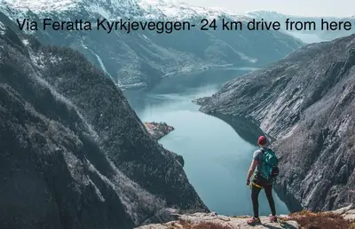 a person standing on top of a mountain overlooking a lake at Apartment-B near Etne-Odda in Etnesjøen