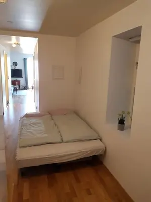 a bedroom with a bed in a room with wooden floors at Flott leilighet på Nygårdshøyden in Bergen