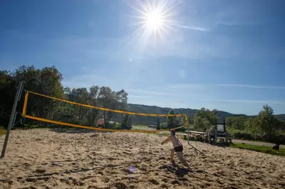 a woman playing volleyball on a sandy beach at Stay in the heart of Geilo, walk to everything in Geilo