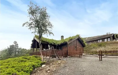 a building with a grass roof with a tree on it at Awesome Home In Hornindal With Wifi in Hornindal